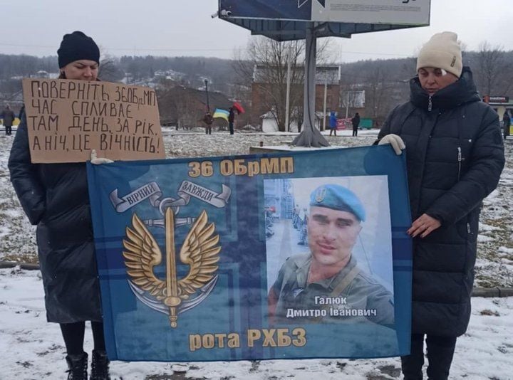 Sorodniki Dmitra Haljaka na shodu podpore z njegovim portretom